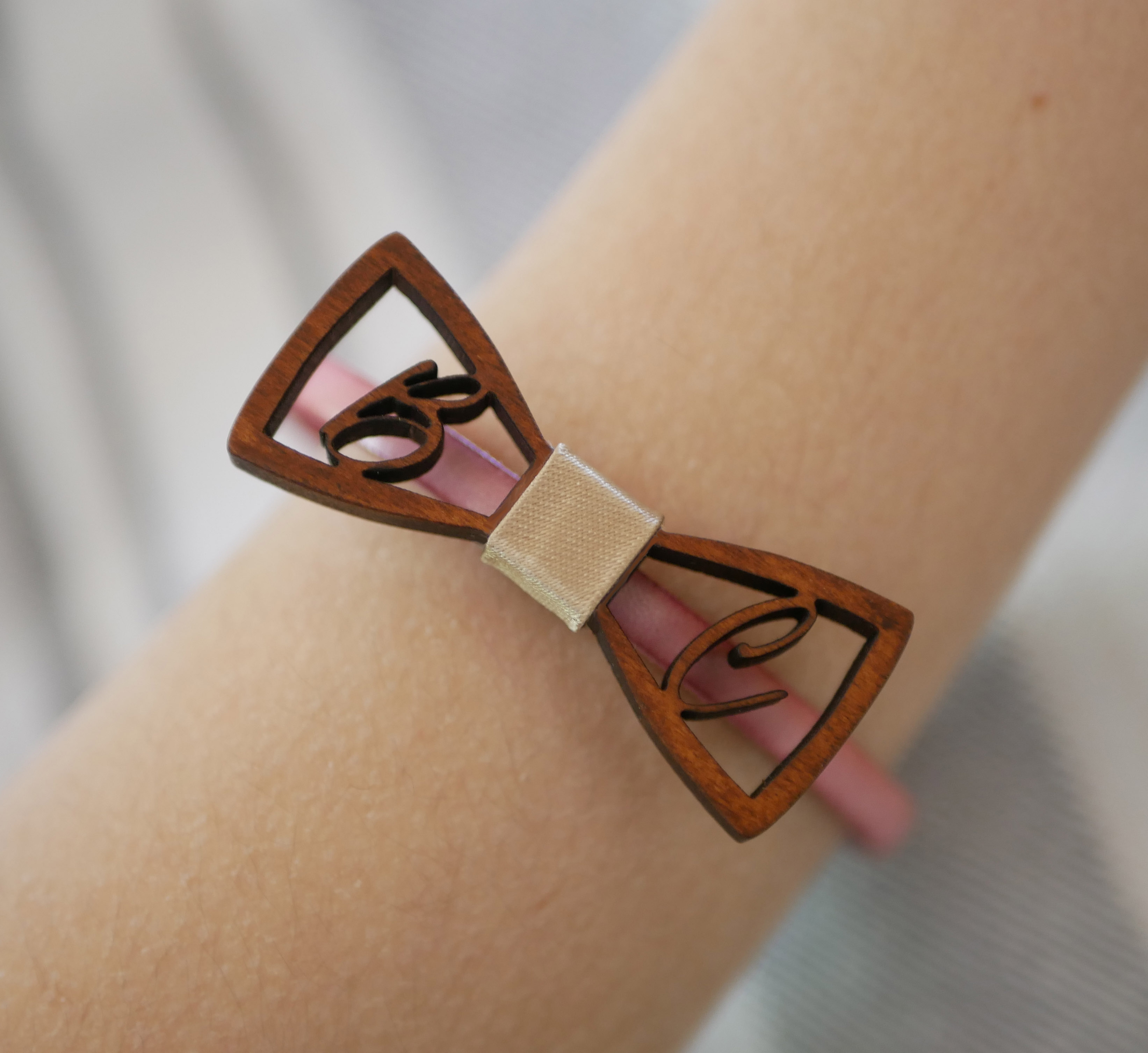 Pulsera de cuero con pajarita de madera en miniatura e iniciales caladas