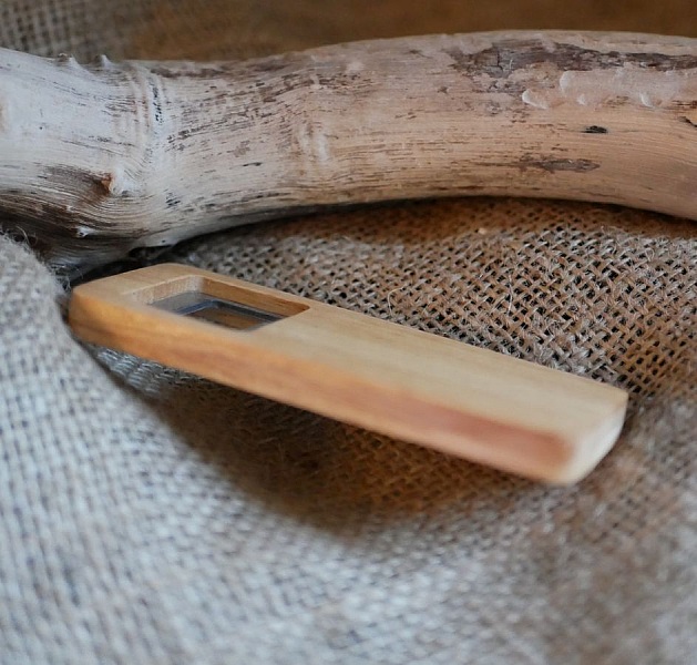 Clé USB en bois naturel sur un fond en toile.