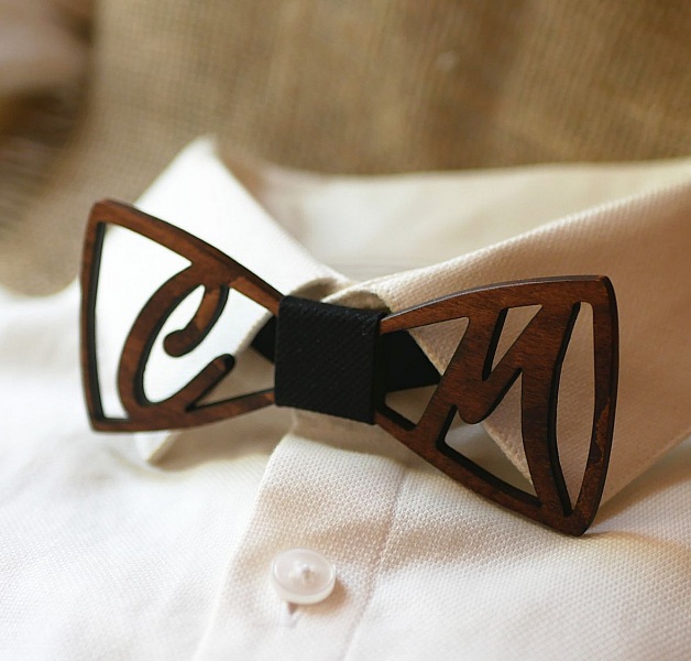 Nœud papillon en bois ajouré sur chemise blanche.