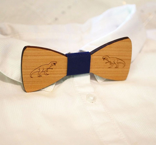 Nœud papillon en bois gravé avec des dinosaures.
